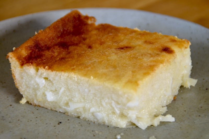 A slice of cassava cake on a grey plate.