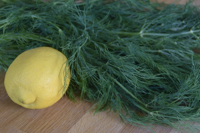 a lemon next to a bunch of dill