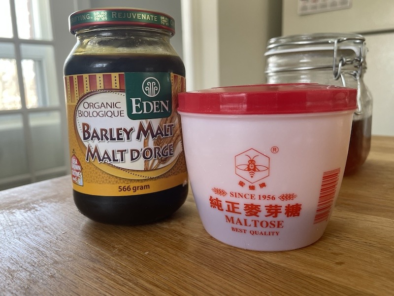 A jar of barley malt syrup next to a container of Chinese maltose.