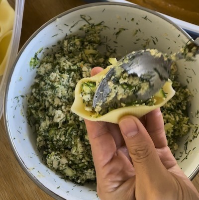 pushing the filling to one side of the pasta shell