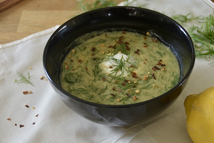 lentil dill lemon soup next to a lemon and some dill on a table