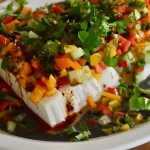 close shot of plated tofu salad with black sesame sauce