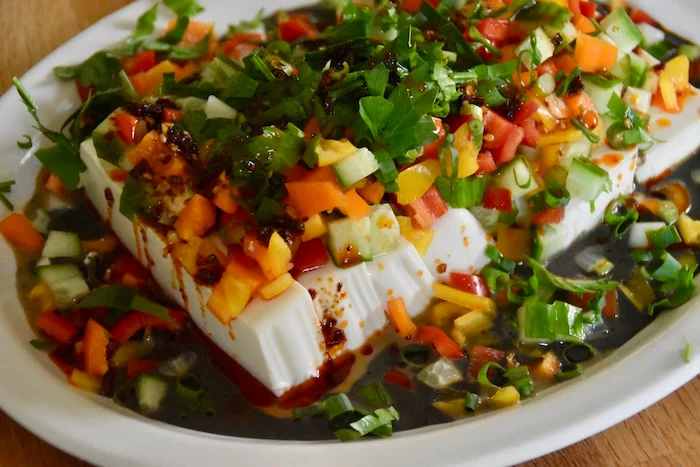 close shot of plated tofu salad with black sesame sauce