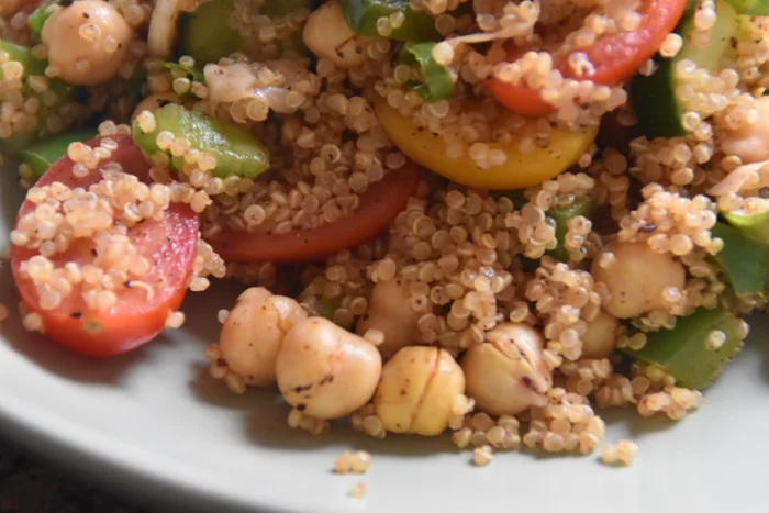 a close up of high protein quinoa salad with chickpeas and vegetables