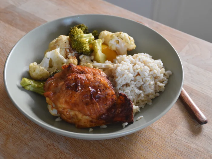 A plate of air fryer soy sauce chicken, vegetables, and brown rice.